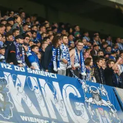 Kibice Lecha Poznań na europejskie puchary, z szalikami i transparentem "AZ DO ŚMIERCI".
