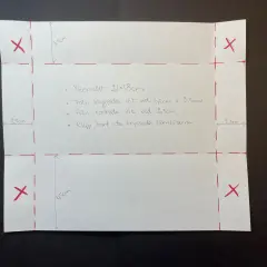 Instruktioner för hur viker man ett kuvert. Papper med mått och röda linjer visar hur man klipper och viker.