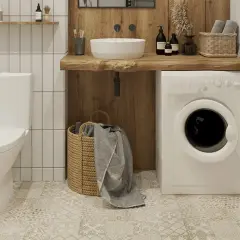 Biały kompakt wc obok pralki i wiklinowego kosza z ręcznikami. Łazienka w stylu rustykalnym.