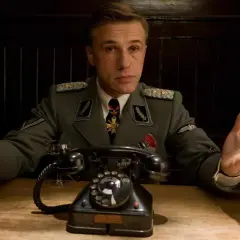 Colonnello Hans Landa, in uniforme, con le mani aperte, in una scena di "Bastardi senza gloria".