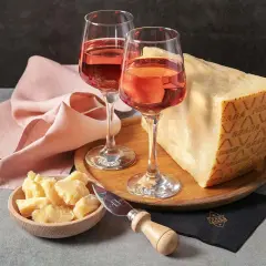 Un bicchiere di vino rosato e un pezzo di Grana Padano, un abbinamento perfetto per un aperitivo.