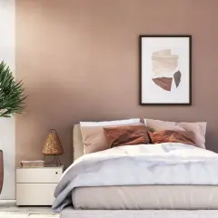 Gemütliches Schlafzimmer mit sanfter, rosafarbener Wandfarbe. Ein großes Bett mit beiger Bettwäsche und braunen Kissen lädt zum Entspannen ein.