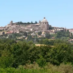 Vista panoramica di Montefiascone, con il suo imponente centro storico arroccato su una collina, che domina il paesaggio verso il lago di Bolsena.