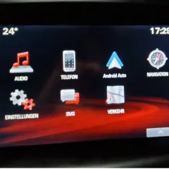 Ekran multimediów w Oplu Astrze K. Widoczne ikony: Audio, Telefon, Android Auto, Nawigacja, Ustawienia, SMS, Ruch. Temperatura 24°, godzina 17:29.
