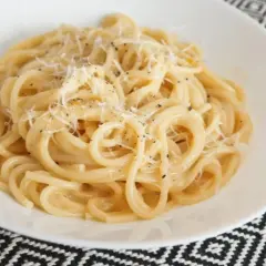 Pyszne spaghetti carbonara z guanciale, posypane parmezanem i świeżo mielonym pieprzem.