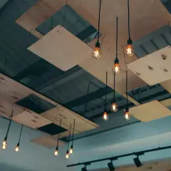 Moderna lampor hänger från ett tak med träpaneler, som om någon ville byta innertak och skapa en unik design.