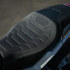 Cuscino sella moto fai da te con cuciture bianche e design geometrico. Comfort e stile per il tuo viaggio.