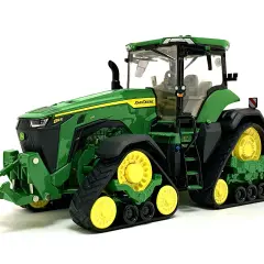 Zielony mini traktor John Deere z żółtymi kołami i gąsienicami, gotowy do pracy na farmie.