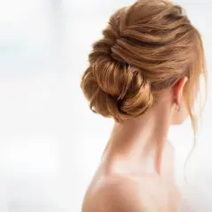 Eleganckie upięcie włosów, idealne dla mamy szukającej wygodnych fryzur. Delikatne fale tworzą stylowy kok.