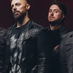 Czterech mężczyzn z zespołu Bullet for My Valentine Polska w rockowych stylizacjach, gotowi na koncert.