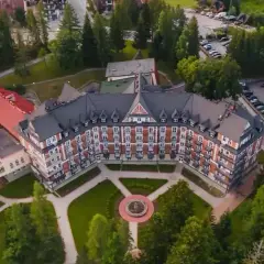 Wojskowy dom wypoczynkowy w Kościelisku, otoczony zielenią, z charakterystyczną architekturą i zadbanym ogrodem.