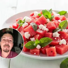 Un hombre sonriente se asoma junto a una refrescante ensalada de sandía con queso feta y menta. ¡Perfecta para el verano!