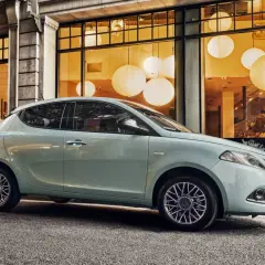 City car 5 posti azzurra parcheggiata davanti a una vetrina con lanterne luminose.