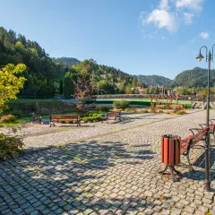 Urokliwa promenada nad Grajcarkiem, z ławkami i latarniami, zaprasza do spacerów wśród zieleni i górskiego krajobrazu.