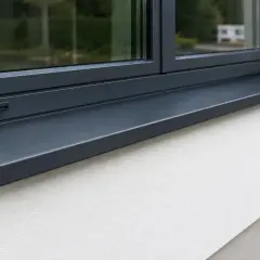 Nowoczesny, grafitowy kapinos parapet chroni elewację przed deszczem.