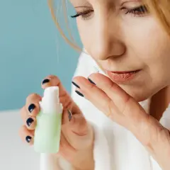 Kobieta po 50. roku życia aplikuje krem. Dbanie o skórę to klucz do zachowania jej elastyczności, podobnie jak gimnastyka twarzy.