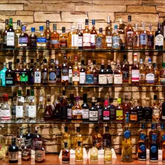 Étagères remplies de bouteilles de whisky et de champagne, un festin pour les amateurs de spiritueux.