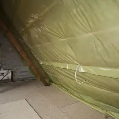 Podczas ocieplania poddasza, odpowiednia folia pod wełnę mineralną na strop zapobiega zawilgoceniu. Widoczna żółta folia paroprzepuszczalna chroni izolację.