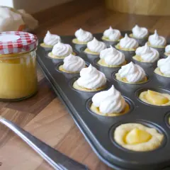 Kleine Törtchen mit Baiserhauben und einer Füllung aus Lemon Curd, bereit für köstliche Rezepte mit Lemon Curd.