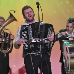 Bum bum orkestar w akcji: akordeonista, tubista i perkusista tworzą energetyczną muzykę na scenie.