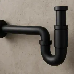 Elegancki, czarny syfon do umywalki, wykonany z matowego metalu, stanowi minimalistyczny element wyposażenia łazienki.