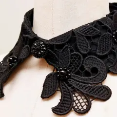 Intricate black lace collar with beaded embellishments, perfect for adding a touch of elegance. Learn how to make a lace collar with this detailed view.