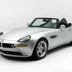 Srebrny kabriolet BMW Z8 na białym tle, z czarnym dachem i wnętrzem. Klasyk motoryzacji.