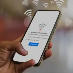 Dłoń trzyma smartfon z komunikatem "Brak połączenia z internetem". Czyżby awaria T-Mobile?