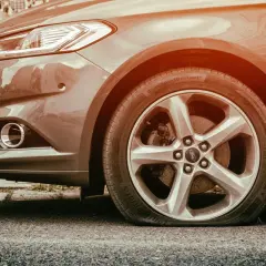 Pneu à plat sur une Ford. L'inconvénient d'une bombe anti-crevaison est qu'elle ne peut pas réparer une crevaison aussi grave.