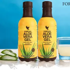 Dwie butelki Forever Aloe Vera Gel, szklanka z napojem i liście aloesu. Wiele pozytywnych forever aloes opinie potwierdza jego jakość.