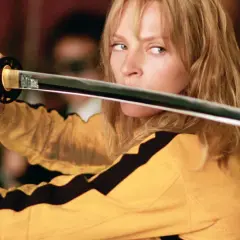 La Sposa, con la sua iconica tuta gialla, impugna la katana. Il suo sguardo è intenso, pronto a vendicarsi. Kill Bill: la benda sull'occhio è un monito.