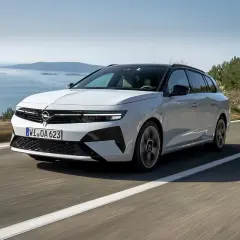 Biała Opel Astra Hybrid na krętej drodze nad morzem.