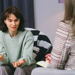 Młoda kobieta opowiada o swoich problemach, co może być początkiem skierowania do psychiatry.