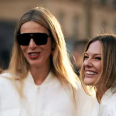 Dos mujeres sonríen, una con gafas de sol y pelo liso rubio, la otra con pelo liso castaño.