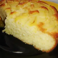 Proste ciasto z kawałkami jabłek, lekko zarumienione na brzegach, podane na czarno-żółtym talerzu.