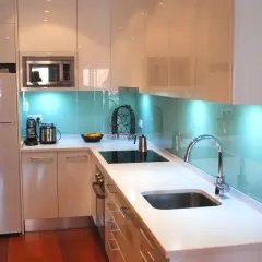 Modernos diseños de cocinas con encimeras blancas, electrodomésticos integrados y un salpicadero azul brillante que ilumina el espacio.