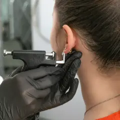 Przekłuwanie ucha, które może powodować ból ucha po przekłuciu chrząstki.