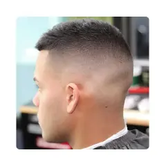 Corte de pelo con un degradado alto (high fade) que se desvanece suavemente desde la nuca hasta la parte superior.