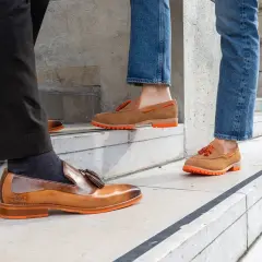 Eleganckie mokasyny do jeansów, z pomarańczową podeszwą i frędzlami, idealne na spacer po mieście.
