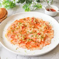 Delicioso carpaccio de gamba roja, finas láminas de gamba cruda con aderezo y picadillo de verduras.