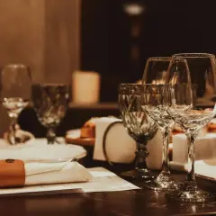 Table dressée avec verres à vin, serviette et bouteille d'eau.