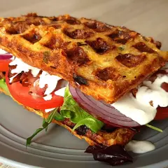 Pyszne keto gofry z mascarpone, pomidorem, czerwoną cebulą i chrupiącym boczkiem. Idealna przekąska.