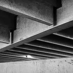 Skomplikowana konstrukcja z betonu, z widocznymi belkami i żebrowaniem. Ta klasa betonu tworzy surowy, architektoniczny krajobraz.