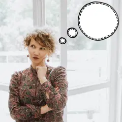 Kobieta z burzą loków zastanawia się nad życiem, szukając inspiracji w powiedzeniach po angielsku.