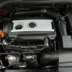 Silnik TSI w Skoda Octavia 2. Widoczne elementy układu dolotowego, zbiorniczek płynu chłodniczego i osłona silnika.