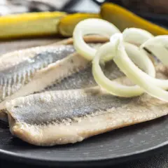 Śledzie w oleju z cebulką i ogórkiem kiszonym – idealny przepis na szybką przekąskę.
