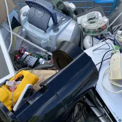 En vagn fylld med elektronik för återvinning av elektronik. En skärm, en stereo, sladdar och andra prylar.