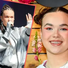 Anastazja piosenkarka w srebrnej kurtce na scenie i uśmiechnięta z kolorowym makijażem.