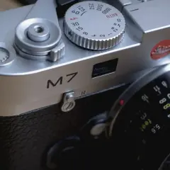 Close-up of a Leica M7 camera, ready for a detailed review. The silver body gleams, showing the "M7" inscription and lens details.