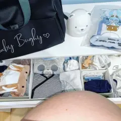 Borsa parto mamma: cosa mettere? Un cassetto organizzato con tutine, body e accessori per il neonato, pronto per l'arrivo.